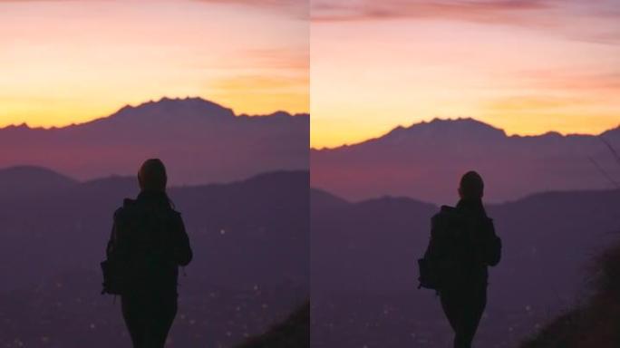 女性徒步旅行站在山顶上，享受新鲜空气，欣赏下面的湖泊、日落和城市