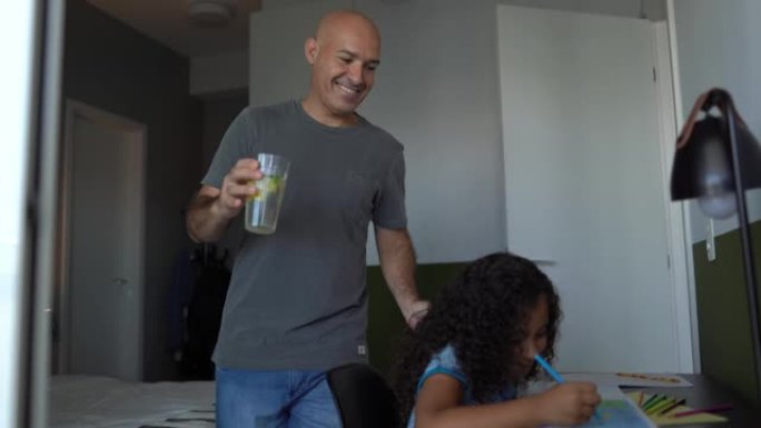 父亲在家里画画时给女儿带了一杯水