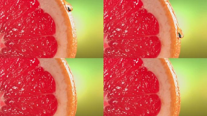 一滴水顺着成熟多汁的柚子片的表面流下来。慢动作4K