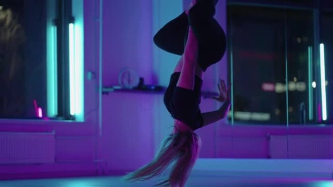 女人倒挂，在做反重力瑜伽练习时使用瑜伽吊床秋千。美丽的年轻女子用吊床做反重力瑜伽姿势的背景图