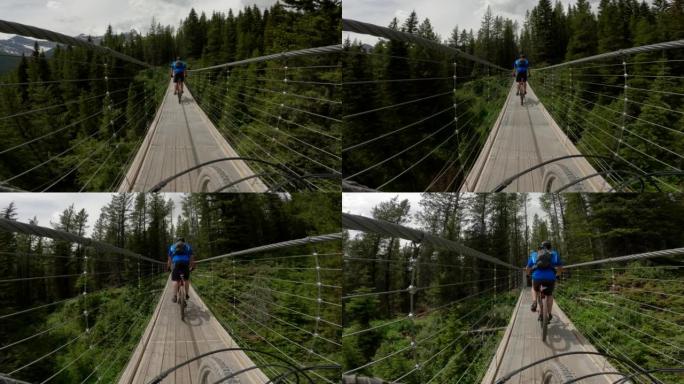山地自行车手穿过悬索桥