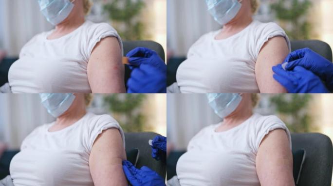 护士在注射疫苗，医疗保健后将创可贴放在高级妇女的手臂上