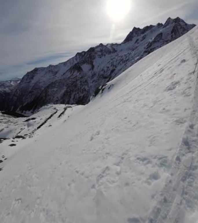 第一人称视角在阳光明媚的日子里在偏远的高山滑雪登山