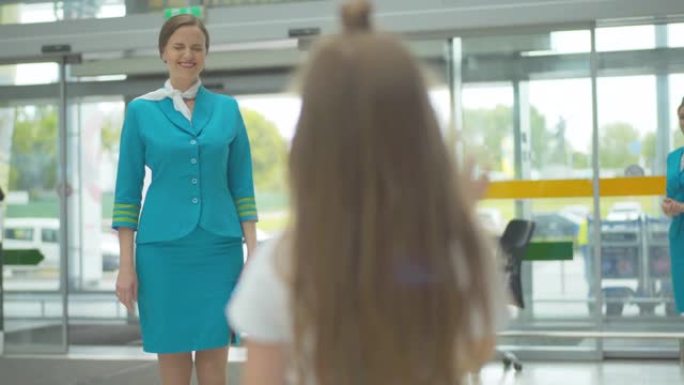 小女孩穿着空姐制服向母亲挥手的后景。模糊的孩子告别父母。在国际旅游领域工作的家庭问题。