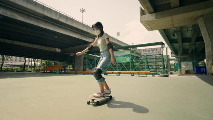 女人玩冲浪板，在高速公路下练习滑冰，她穿着防护服。