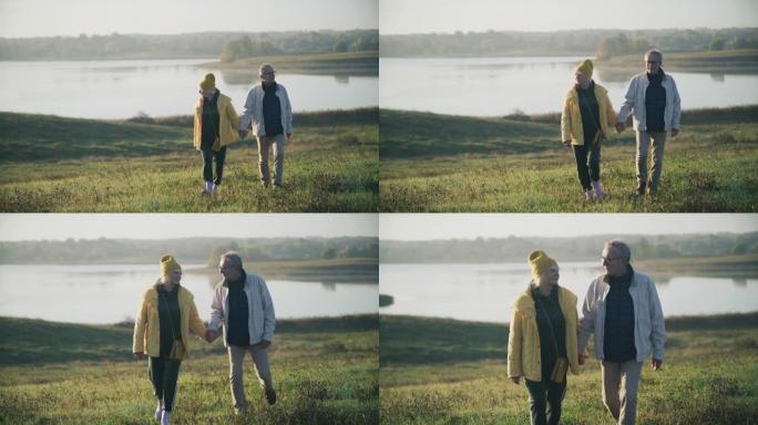 充满爱心的老年夫妇一起在湖边散步和牵手
