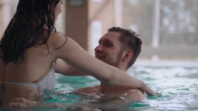 快乐的人们在现代健康中心的热水浴中休息，男人和女人一起游泳