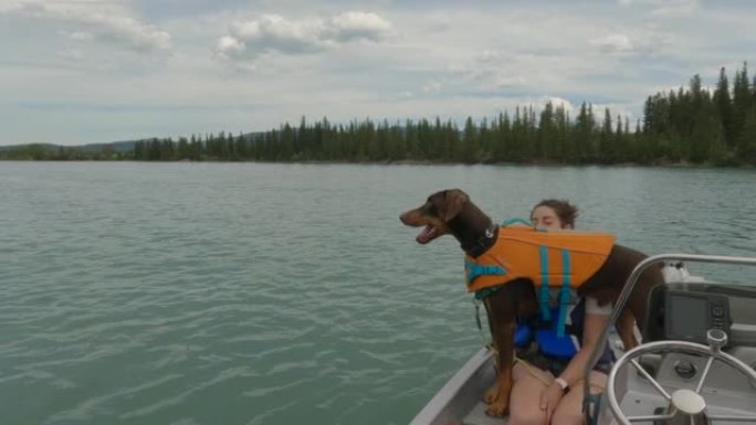 山河沿岸的年轻夫妇和狗领航快艇