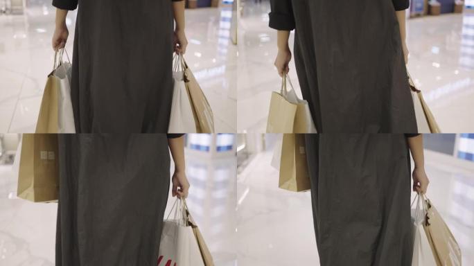 女人背着购物袋在购物中心醒来