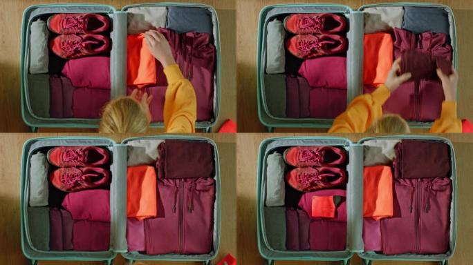 LD女人在旅行时用运动服收拾行李箱
