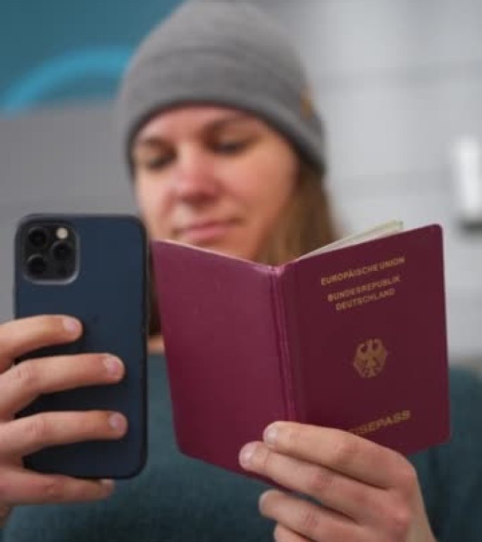 一名妇女在机场翻阅德国护照的垂直细节照片