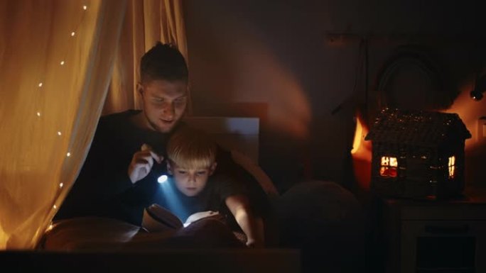 一位父亲和儿子躺在床上，在提着灯笼睡觉前给他读了一个童话。和我儿子一起读一本书，摇篮曲。父亲和儿子在