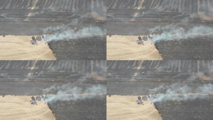 扑灭了农田大火。就在一片庄稼着火后。直升机的鸟瞰图。棕灰色的烟雾和红色的小火焰。