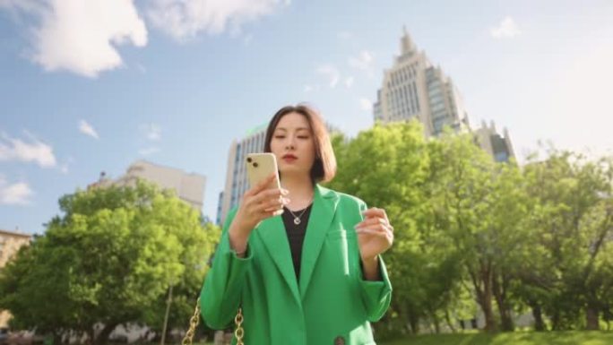 手里拿着现代智能手机的美丽有钱的日本女人独自行走