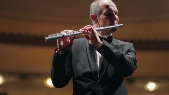 才华横溢的长笛演奏家正在用长笛演奏新古典音乐，这是爱乐音乐厅的音乐家肖像