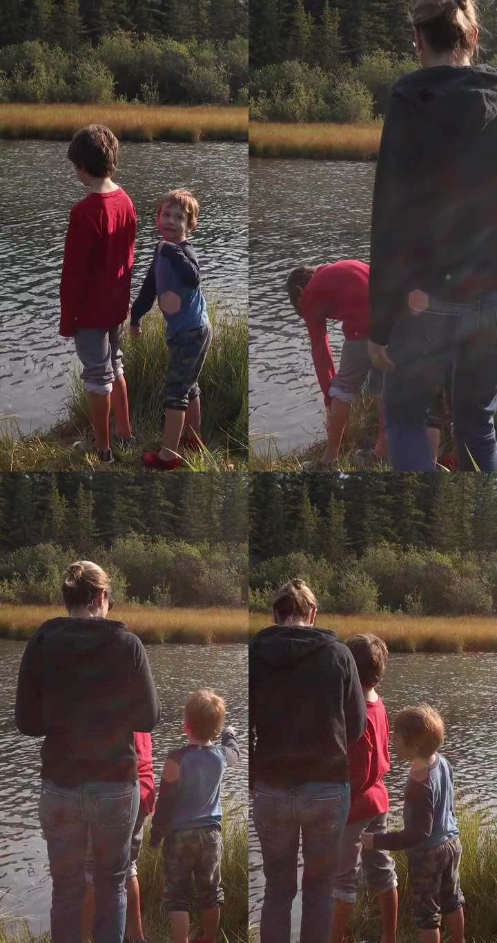 母亲和年幼的儿子在creek edge放松，喂鸭子