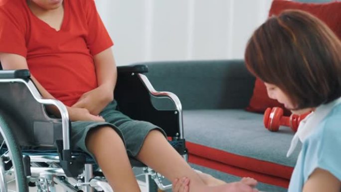 理疗师女性正在家里照顾一个残疾男孩。
