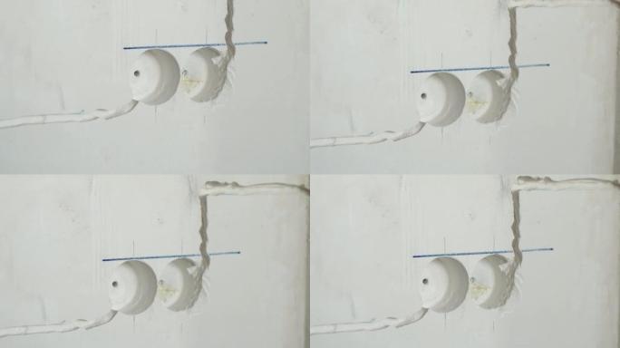 用于铺设电缆的频闪线。接线维修和更换概念。房间的抹灰墙壁，带有用于安装接线附件的电气接线的频闪
