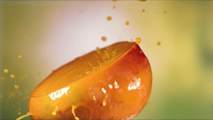 一半新鲜的黄色芒果果汁滴，一半芒果上溅汁
