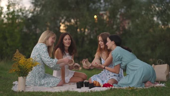 一群年轻的有吸引力的女人在一个开放的区域，从粘土雕刻，讨论课程的结果，交流，分享他们的印象，大笑，为