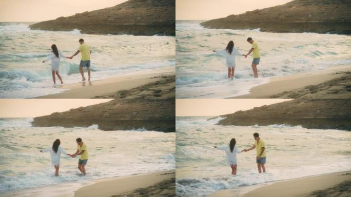 恋爱中的异性恋浪漫情侣。阳光明媚的日子牵着手在海滩上浪漫散步