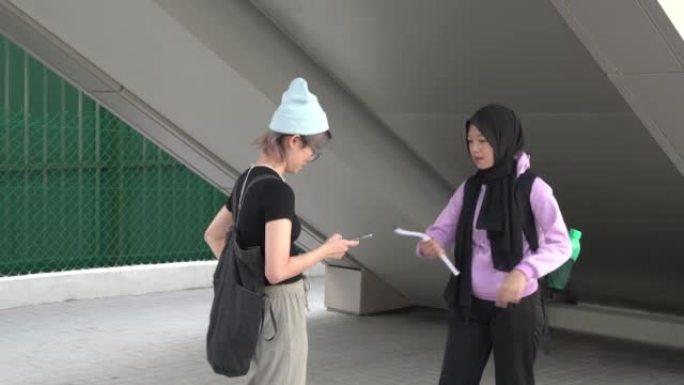 两个亚裔女大学生朋友互相交谈。