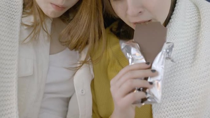 不高兴的少女吃巧克力棒，抑郁症，饮食失调，暴饮暴食
