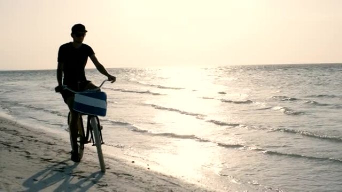 年轻人在海滩上骑自行车穿过退潮