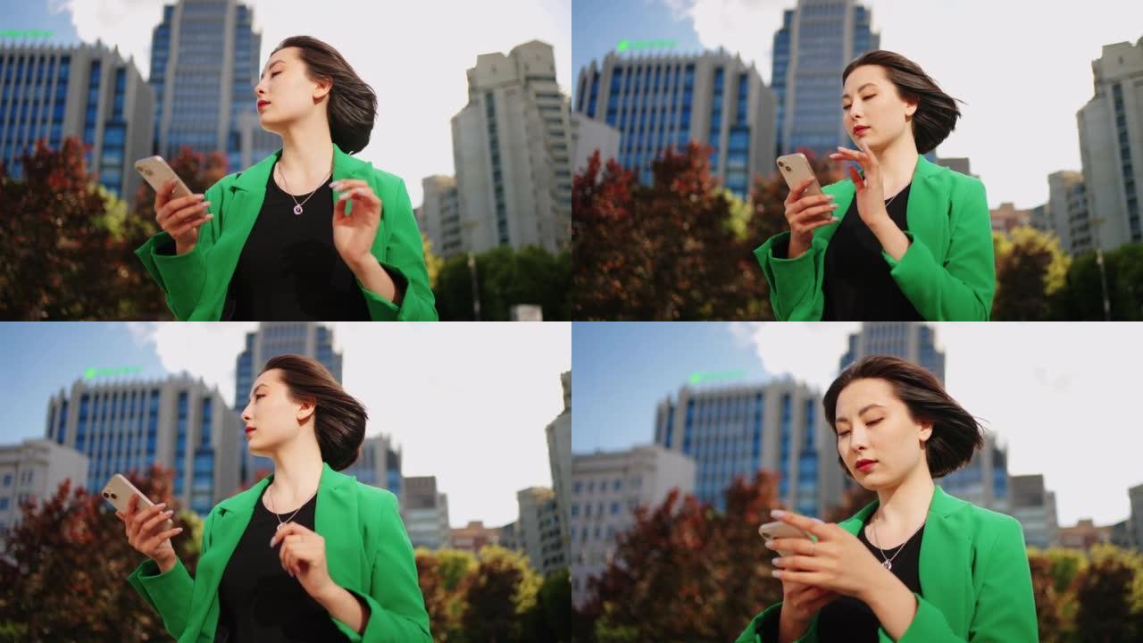 自信独立的亚洲女士，智能手机，城市景观中的肖像
