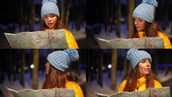 苗条美丽的高加索女人的肖像，想着站在户外用纸质地图选择路线。犹豫不决的不确定迷人的女性游客在冬季森林