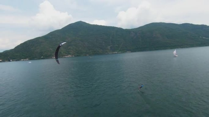 空中无人机拍摄了一名男子在山上的湖上冲浪的风