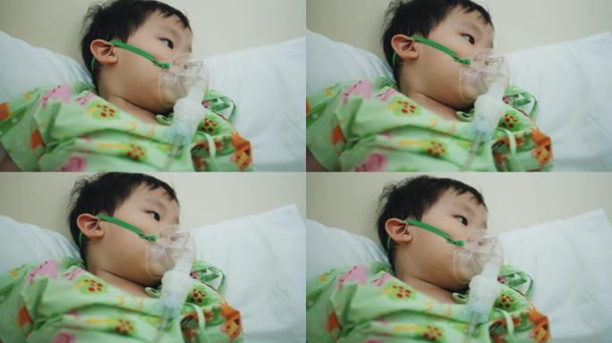 在医院接受氧气雾化器治疗的蹒跚学步的男孩。支气管炎和肺部疾病的吸入器治疗