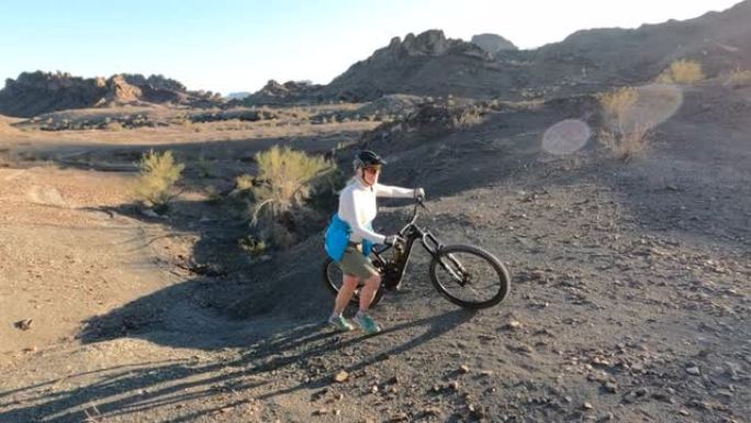 沙漠山脊小径上的成熟女性电动自行车