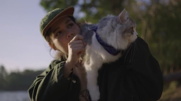 女人肩上扛着一只猫在外面