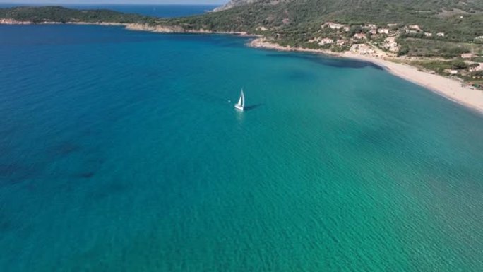 白色帆船在Cargese附近的沙滩上驶过碧蓝清澈的海水的鸟瞰图