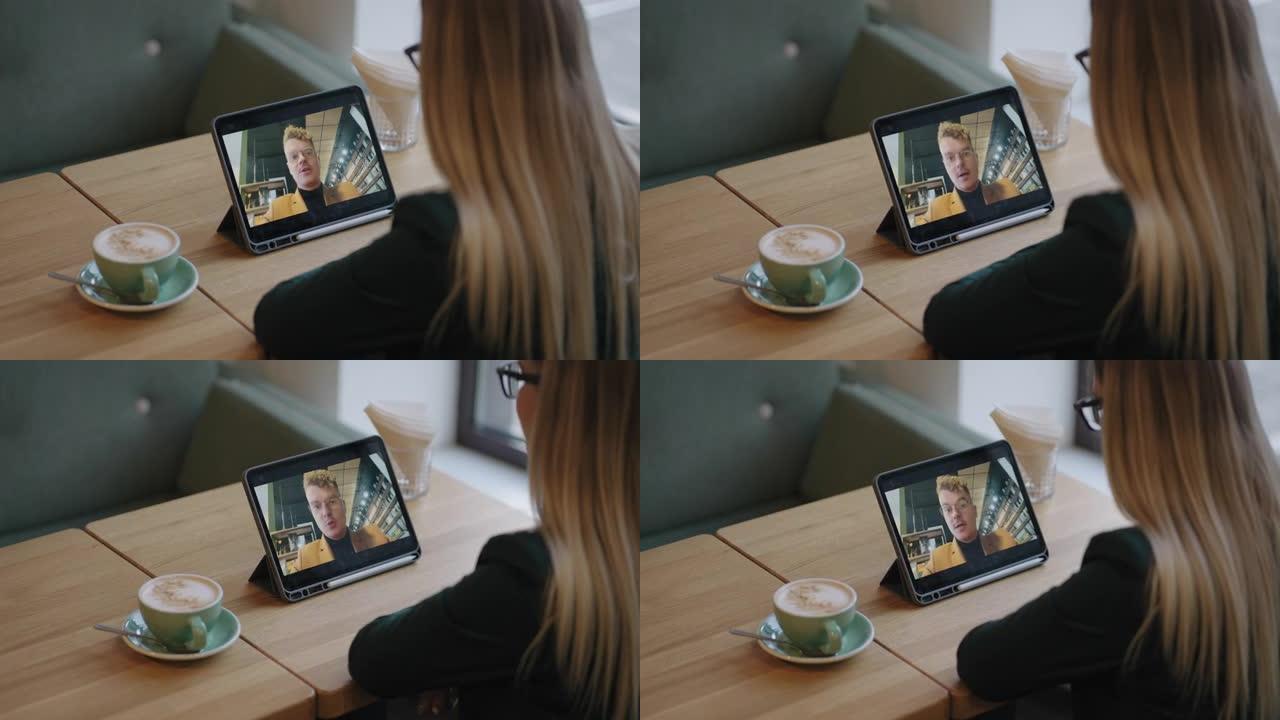 金发女子正在与男友或同事男子通过视频通话聊天，独自坐在咖啡店里