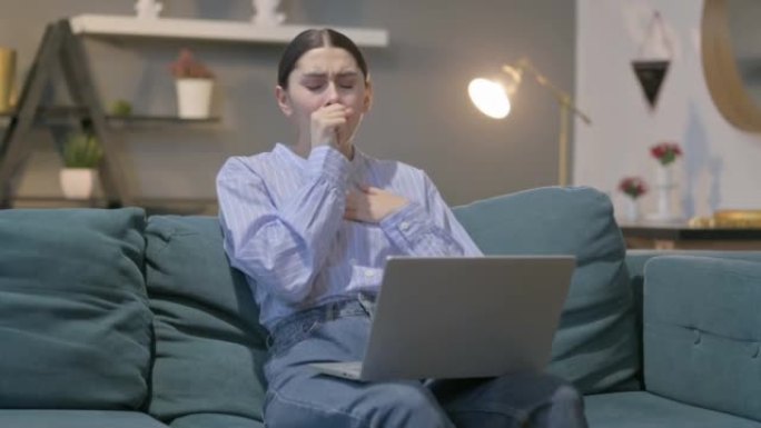 西班牙裔妇女，笔记本电脑在沙发上咳嗽
