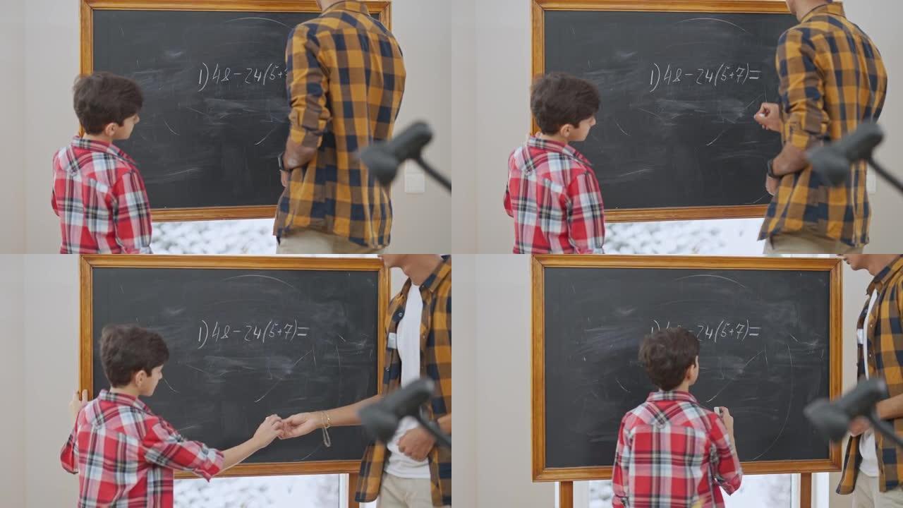 中东老师在黑板上写算术表达式，并将粉笔传给解决数学问题的小男孩。集中男孩在教室学习数学的后视图。