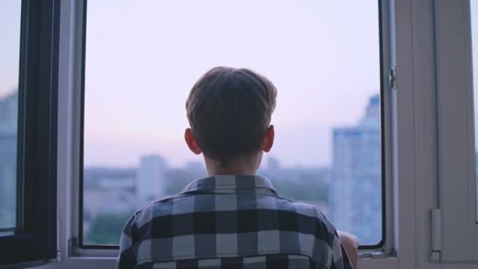 十几岁的男孩透过窗户看，悲伤的孤儿等待收养的背景图