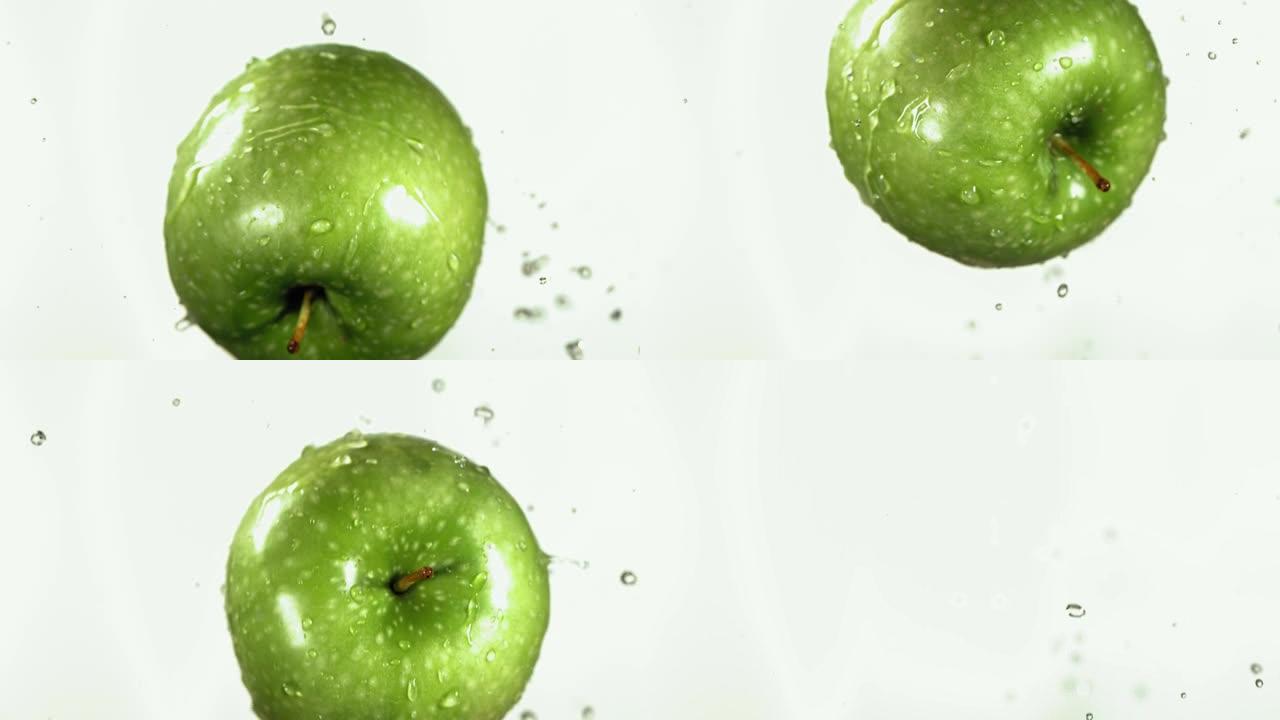 绿色苹果在白色厨房背景下的慢动作飞行