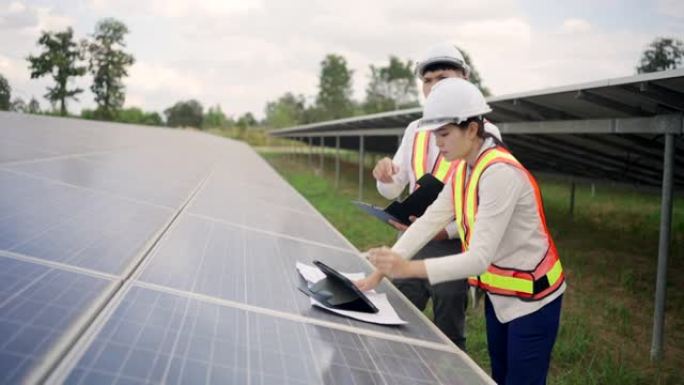 太阳能电池板发电站，电气工程师检查建筑物外的太阳能电池农场。