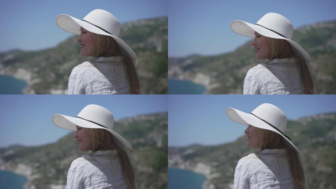 戴着白帽子的年轻女子在阳光明媚的日子里看着海景
