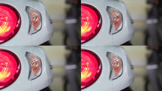 在交通道路上驾驶摩托车时的特写提示灯。白色背景。现代摩托车