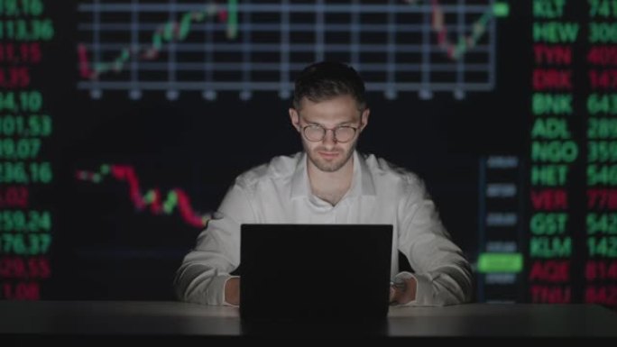 年轻的高加索人交易员在监控笔记本电脑工作，并在交易办公室在线浏览。遵循利率和赌注的男性经纪人。经理在