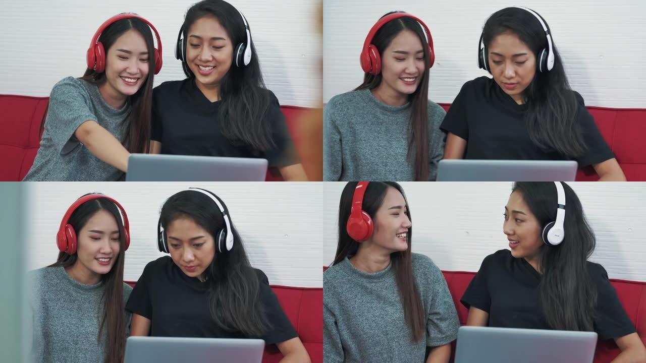 两个年轻的女人戴着耳机听音乐，用笔记本电脑在家