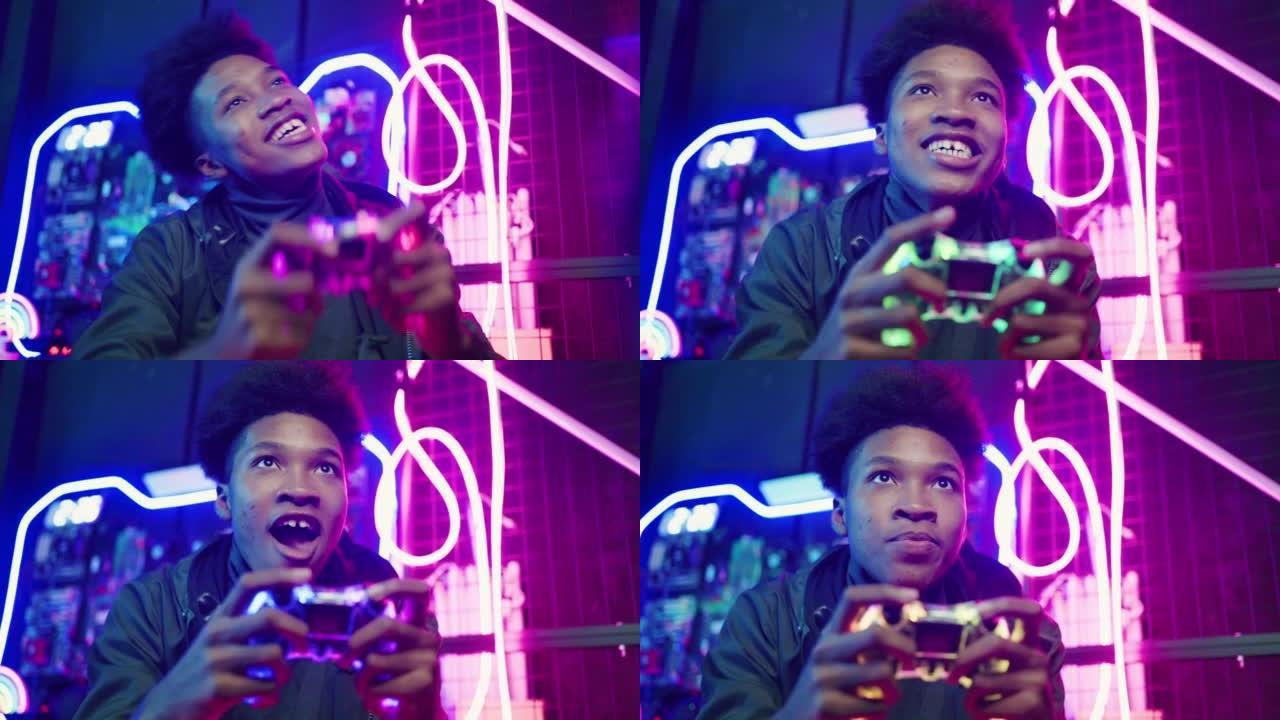 英俊兴奋的年轻黑人游戏玩家坐在沙发上，在游戏机上玩视频游戏并获胜
