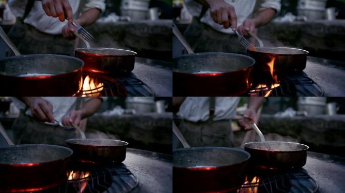 一名男子在室外炉灶上检查食物烹饪的慢动作镜头