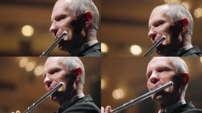 老年音乐家正在演奏长笛，男性面孔和管乐器的特写镜头，音乐会中的长笛演奏家