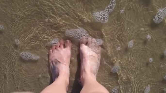 女人脚踩沙浪