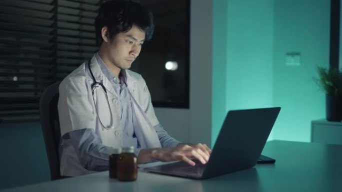 医生在诊所深夜使用笔记本电脑